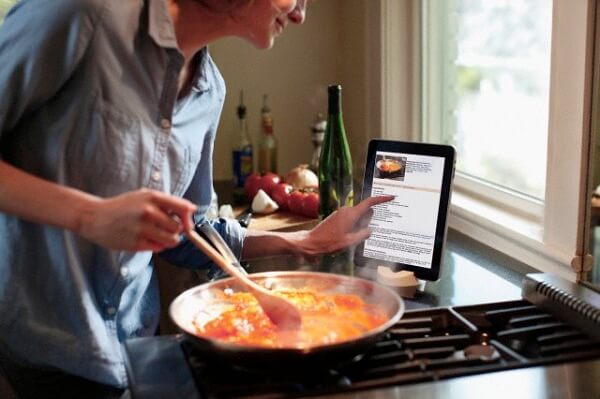 Person cooking and interacting with a recipe displayed on a tablet --- Image by © Ron Royals/Corbis